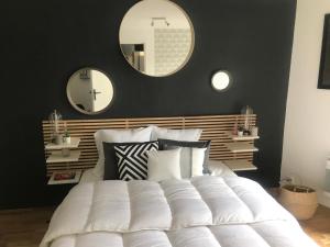 a bedroom with a large white bed with two mirrors at Hullman Suite Apartment 4 People Between La Défense and Paris in Asnières-sur-Seine