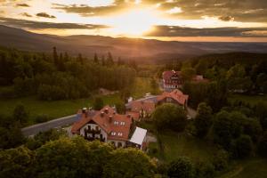 an aerial view of a house on a hill with the sunset in the background at L&B Spa in Karpacz