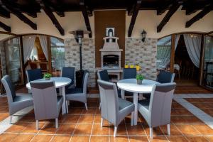 a patio with tables and chairs and a fireplace at L&B Spa in Karpacz