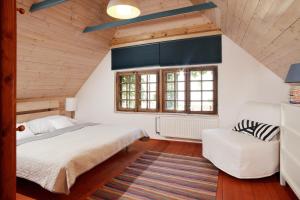 a bedroom with a bed and a chair in a attic at Galerie Napoli in Bystřec