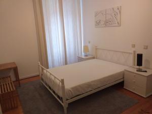 a bedroom with a white bed and a television on a table at Casa Abrigo do Lagar in Amares