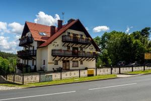 a white house with balconies on the side of a road at L&B Spa in Karpacz