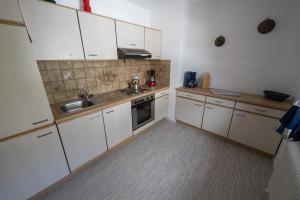 een kleine keuken met witte kasten en een wastafel bij Appartement Pavillon in Fulpmes