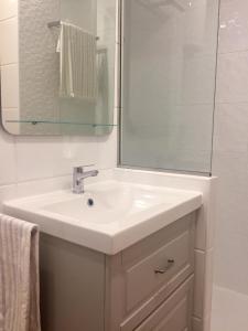 uma casa de banho com um lavatório branco e um espelho. em Bedonbeach em Las Palmas de Gran Canaria