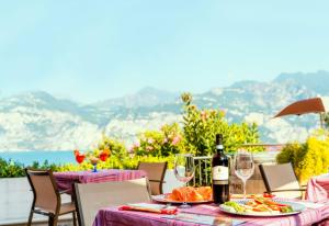 a table with a bottle of wine and glasses at Hotel Antonella in Malcesine
