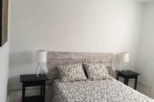 a bedroom with a bed with two nightstands and two lamps at Big, large cozy apartment with sea view ask for additional bedroom as an extra option in Telde