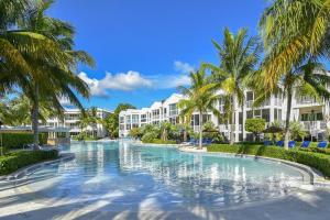 a swimming pool with palm trees in front of a resort at LICENSED MGR - LUXURIOUS OCEANFRONT CONDO W/STUNNING VIEWS - UPSCALE OCEANFRONT RESORT! in Key Largo