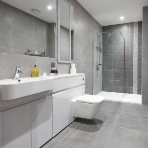 La salle de bains est pourvue de toilettes, d'un lavabo et d'une douche. dans l'établissement Luxustay Milburn House, à Milton Keynes