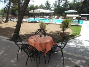 a table and chairs with a table and a pool at Residence MILANO in Chieuti