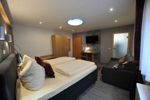 een hotelkamer met een bed en een bank bij Hotel-Restaurant Ehses in Zeltingen-Rachtig