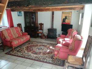 sala de estar con 2 sillas y chimenea en La Petite Maison, en Beauchêne