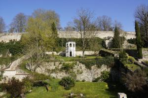 - un vieux bâtiment en pierre avec un jardin en face dans l'établissement Gîte la Chancellerie, à Château-Thierry