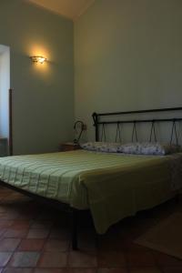 a bedroom with a bed with a green bedspread at Agriturismo Il Castagneto in Supino