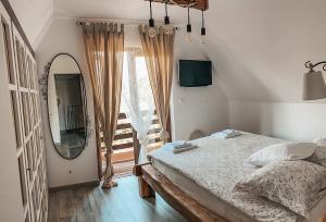 a bedroom with a bed and a mirror and a window at By Riverhill in Karlovac +19 photos