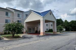 um grande edifício branco com um telhado azul em Country Inn & Suites by Radisson, Fayetteville I-95, NC em Fayetteville