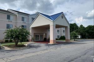 a large white building with a blue roof at Country Inn & Suites by Radisson, Fayetteville I-95, NC in Fayetteville