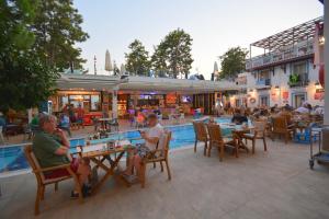 a group of people sitting at tables by a pool at Istankoy Hotel in Bodrum City