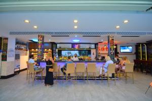 a group of people sitting at a bar in a restaurant at Istankoy Hotel in Bodrum City