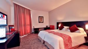 ラバトにあるMercure Shéhérazade Rabatのベッド1台、薄型テレビが備わるホテルルームです。