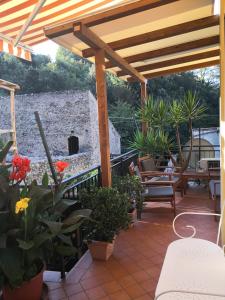 "Lemon Tree House" Relax&Bike in campagna a Finale Ligure con Air Cond في اوركو فيغلينو: فناء به بريغولا خشبي وبعض النباتات