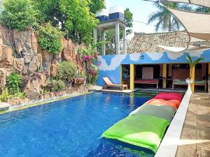 una piscina con almohadas coloridas en el lateral de una casa en Binaria Museum Hotel en Lovina