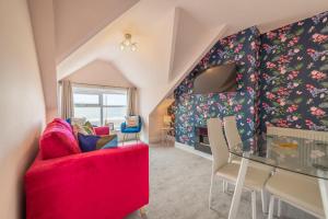 a living room with a red couch and a table at Charles Alexander Short Stay - Highcliffe Apartments in Cleveleys