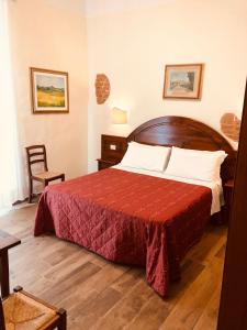 um quarto com uma cama grande e um cobertor vermelho em Hotel Nizza em Florença