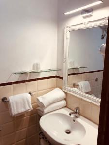 a bathroom with a toilet, sink and mirror at Hotel Nizza in Florence