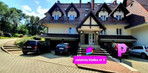 a house with two cars parked in front of it at VIP Apartamenty Centrum2 in Zakopane