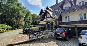 a house with two cars parked in front of it at VIP Apartamenty Centrum2 in Zakopane