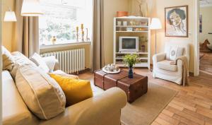 ein Wohnzimmer mit einem Sofa und einem Tisch in der Unterkunft Immenhof in Flensburg
