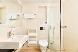 a bathroom with a sink and a toilet and a shower at Hotel Mediteran Plava Laguna in Poreč