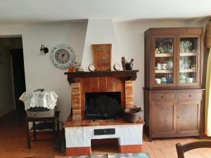 salon z kominkiem i szafką w obiekcie Poggio Bicchieri w mieście Campiglia dʼOrcia