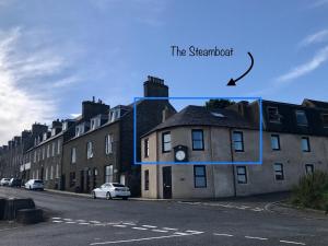 a building with a clock on the side of it at The Steamboat - A Flat with Amazing Harbour Views in Wick