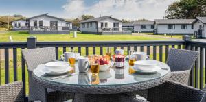 Una mesa con comida y bebidas en un balcón. en Bude Holiday Resort, en Bude
