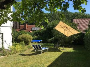 una silla, una mesa y una sombrilla en el patio en Vor den Toren Bambergs - Einfamilienhaus mit Garten!, en Viereth-Trunstadt