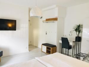 een witte woonkamer met een tafel en stoelen bij Hotel MoinMoin in Bad Bramstedt
