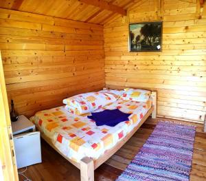 a bedroom with a bed in a log cabin at Retezat Retreat - wood cabin in Clopotiva