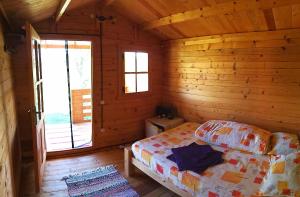a bedroom with a bed in a log cabin at Retezat Retreat - wood cabin in Clopotiva