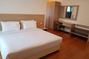 關丹的住宿－Relax @ Bukit Gambang Resort City，卧室配有一张白色大床和一张书桌