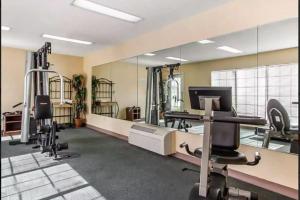 a gym with several tread machines and mirrors at Baymont by Wyndham Selma in Selma
