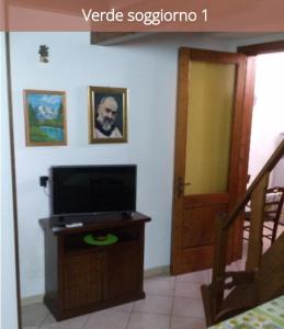 een woonkamer met een tv en een deur bij Rosina in Cannole