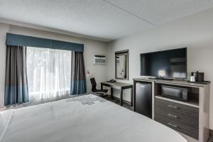 Voodi või voodid majutusasutuse Days Inn & Suites by Wyndham Spokane toas