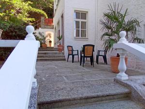 a white fence in front of a house with chairs at Pension Baron Schoeneck in Karlovy Vary