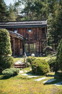 a log cabin with a garden in front of it at Hotel Chalet Corso in San Vigilio Di Marebbe