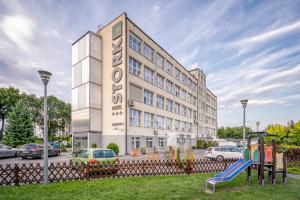 um edifício com um parque infantil em frente em Hotel Stork em Brodnica