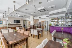 a restaurant with tables and chairs and a bar at Hotel Stork in Brodnica