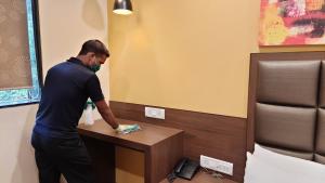 a man standing at a desk in a hotel room at Hotel Amigo in Mumbai