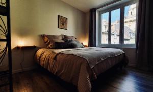 sypialnia z łóżkiem i dużym oknem w obiekcie "L'imprévue", standing au pied de Notre-Dame w mieście Boulogne-sur-Mer