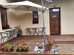 a patio with an umbrella and tables and chairs at Ubytovanie Home Katka in Bešeňová